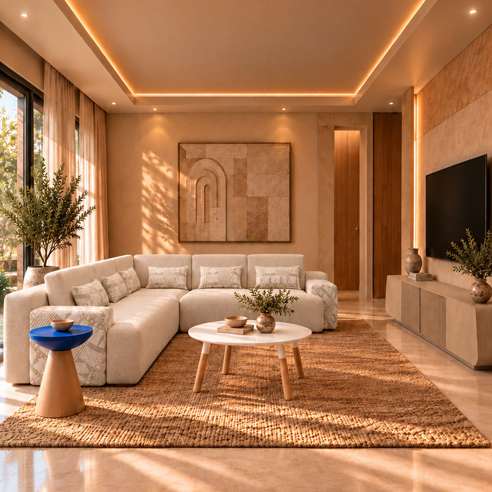 Warm living room with beige corner sofa, white round coffee table, cobalt-blue Cone side table and a pale wood TV unit.